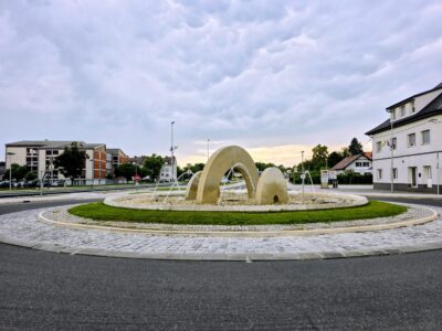 Radenska fontana s kapljičnimi oboki v krožišču pri Panonski in Radgonski cesti govori v jeziku vode: kraj, ki živi od vrelcev, je svoj prometni otok spremenil v tekoč mestni podpis.